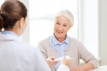 Image showing doctor giving prescription to senior woman