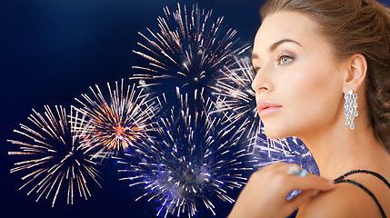 Image showing beautiful woman with diamond earring over firework