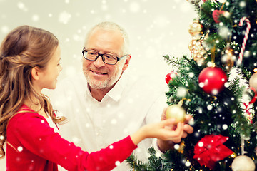 Image showing smiling family decorating christmas tree at home