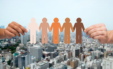 Image showing hands with people pictogram over city background