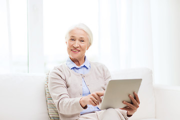 Image showing happy senior woman with tablet pc at home