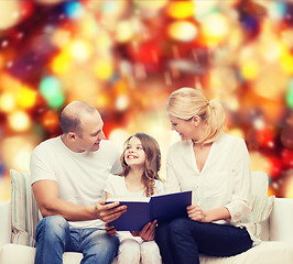 Image showing happy family with book at home