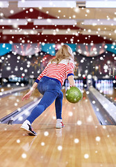 Image showing happy young woman throwing ball in bowling club