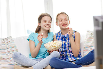 Image showing happy girls with popcorn watching tv at home