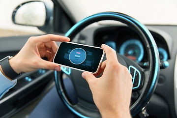 Image showing hands with start engine icon on smartphone in car