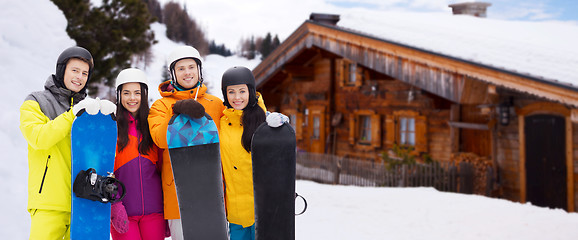 Image showing happy friends in helmets with snowboards outdoors