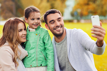 Image showing happy family taking selfie by smartphone outdoors