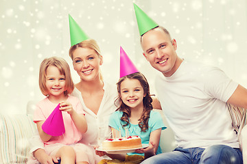 Image showing happy family with two kids in party hats at home