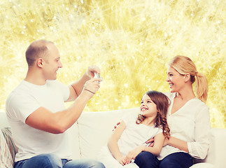 Image showing happy family with camera at home