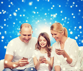 Image showing happy family with smartphones