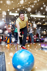 Image showing happy young man throwing ball in bowling club