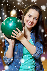 Image showing happy young woman holding ball in bowling club