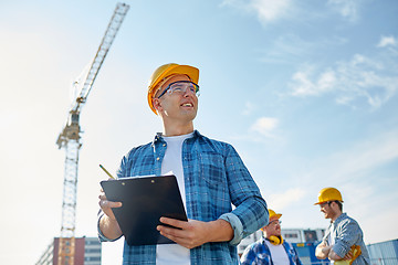 Image showing builder in hardhat with clipboard at construction