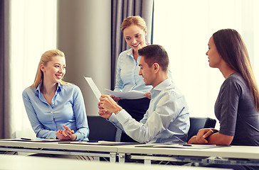 Image showing smiling business people with papers in office