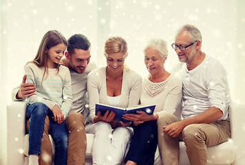 Image showing happy family with book or photo album at home