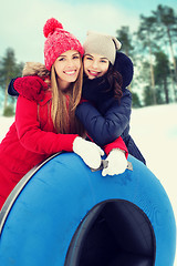 Image showing happy girl friends with snow tubes outdoors