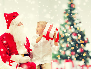 Image showing smiling little boy with santa claus and gifts