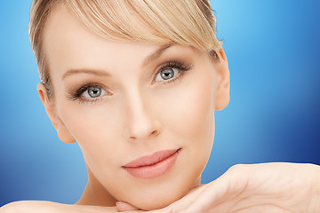 Image showing beautiful young woman face over blue background