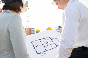 Image showing close up of architects with blueprint at building