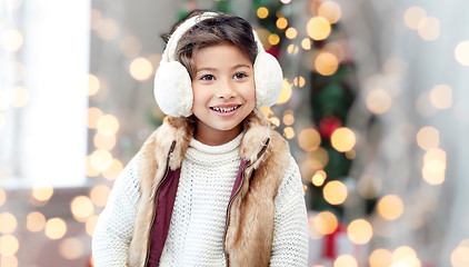 Image showing happy little girl wearing earmuffs at christmas