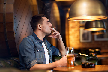 Image showing man drinking beer and smoking cigarette at bar