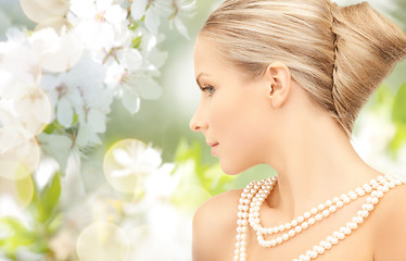 Image showing woman with pearl necklace over cherry blossom