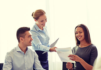 Image showing smiling business people with papers in office