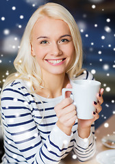 Image showing happy young woman drinking tea or coffee