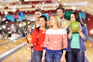 Image showing happy friends taking selfie in bowling club