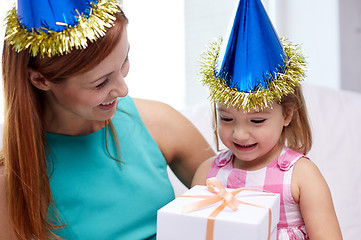 Image showing happy mother and child in party caps with gift box