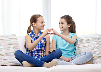 Image showing happy little girls showing heart shape hand sign