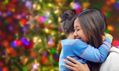 Image showing happy mother and daughter hugging over lights