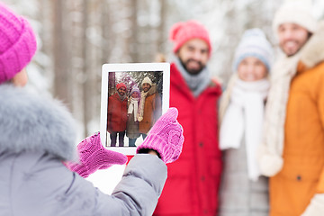 Image showing happy friends with tablet pc in winter forest