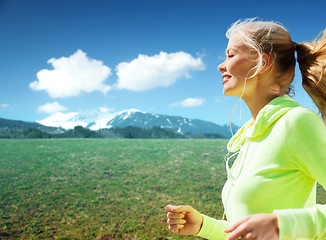 Image showing happy sporty woman running or jogging outdoors