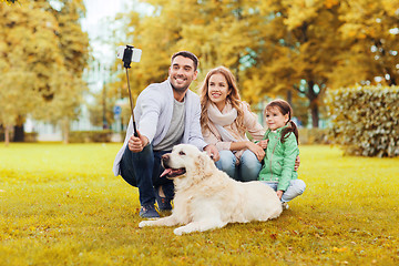 Image showing happy family with dog taking selfie by smartphone