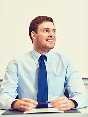 Image showing smiling businessman sitting in office