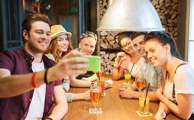 Image showing happy friends with smartphone taking selfie at bar