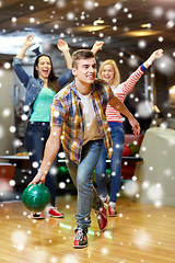 Image showing happy young man throwing ball in bowling club