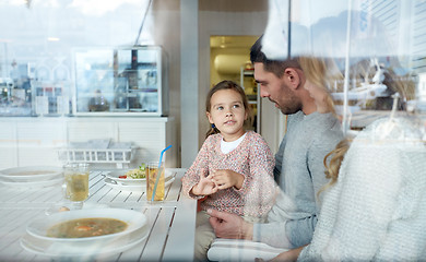 Image showing happy family having dinner at restaurant or cafe