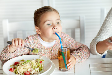 Image showing little girl drinking apple juice at restaurant