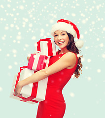 Image showing woman in santa helper hat with many gift boxes