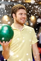 Image showing happy young man holding ball in bowling club