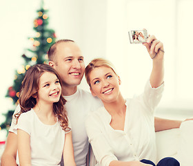 Image showing happy family with camera at home