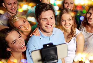 Image showing friends with smartphone taking selfie in club