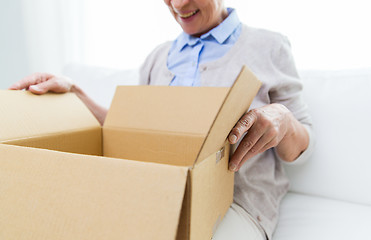 Image showing close up of senior woman with parcel box at home