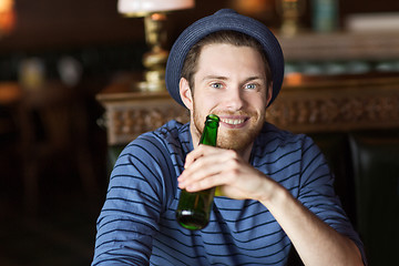 Image showing happy young man drinking beer at bar or pub