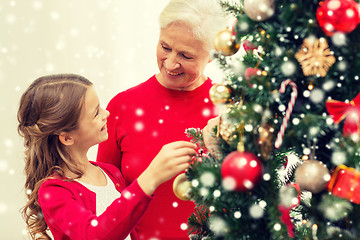 Image showing smiling family decorating christmas tree at home