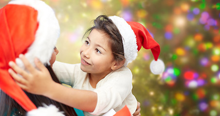 Image showing happy mother and little girl in santa hats