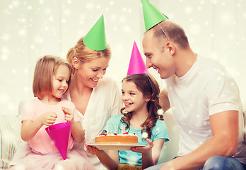 Image showing happy family with two kids in party hats at home