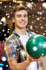 Image showing happy young man holding ball in bowling club